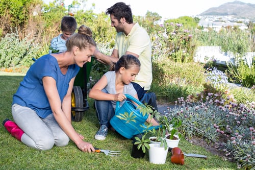 Happy young family gardening together in the garden