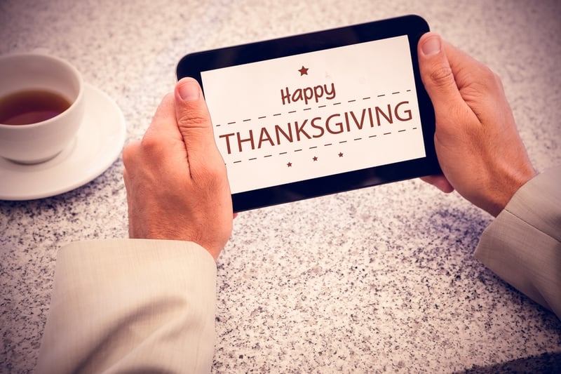Businessman holding small tablet at table against happy thanksgiving.jpeg