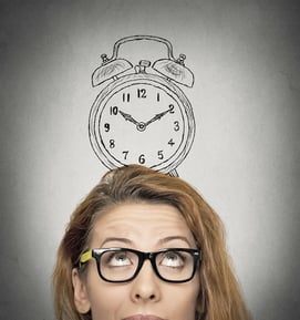 young business woman with alarm clock drawing sketch above her head, isolated grey wall background. Human face expressions, emotions. Time, punctuality, busy schedule concept
